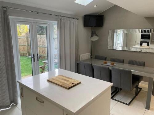 a kitchen with a white counter top and a table at The Townhouse @Thorpe Road in Peterborough