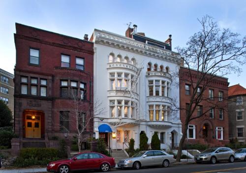 un edificio blanco con coches estacionados frente a él en American Guest House en Washington