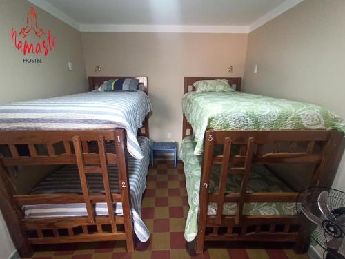 two twin beds in a room with at Namaste Hostel in Tarija