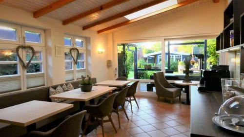 a restaurant with tables and chairs and windows at Blaues Haus in Glückstadt