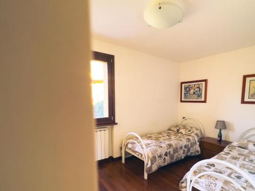 a bedroom with two beds and a window at Tenuta MonteOliveto - Family Cottage - Agriturismo nelle Langhe in Vesime