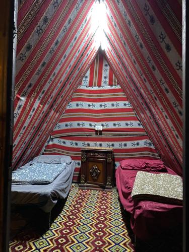 a room with two beds in a room with a wall at Wadi Al-Hassa camp in Khawkhah