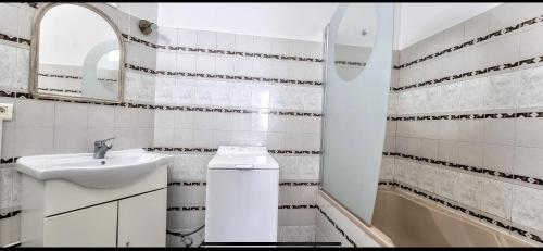 une salle de bain blanche avec un lavabo et un miroir dans l'établissement APPART f3 ,CLIM, PROCHE PLAGE, à Banyuls-sur-Mer