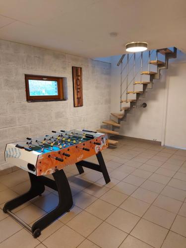 a foosball table in a room with a staircase at L'Éphém'Heer in Hastière-par-delà