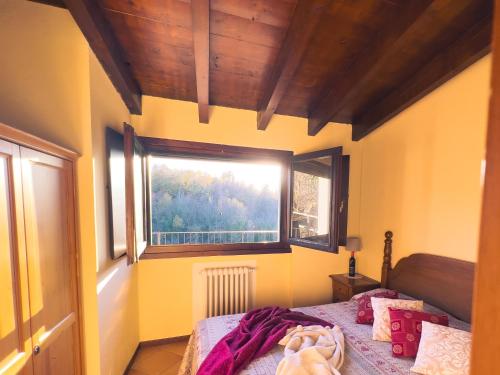 a small bedroom with a bed and a window at Tenuta MonteOliveto - Cottage Relax - Agriturismo nelle Langhe in Vesime