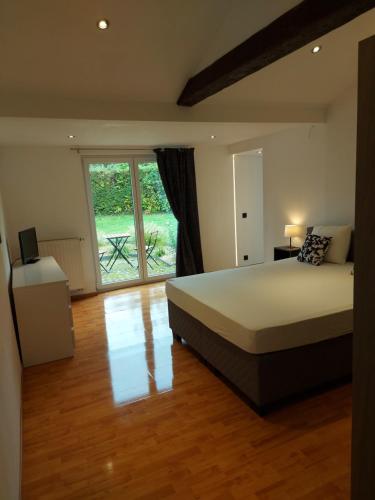 a bedroom with a large bed and a large window at L'Éphém'Heer in Hastière-par-delà