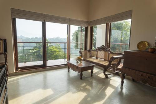 a living room with a couch and large windows at Edgar Mansion Kandy in Kandy