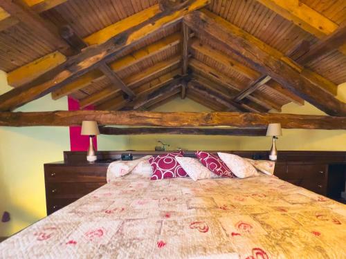 a bedroom with a large bed with wooden ceilings at Agriturismo - Tenuta MonteOliveto - Cottage Romantic in Vesime