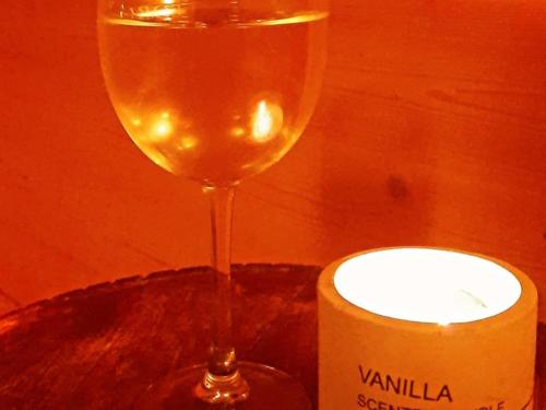 a wine glass sitting next to a bottle of wine at Location Tiny House Loule in Loulé