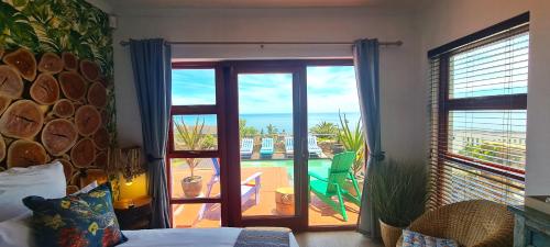a bedroom with a door open to a patio with a view at Beachwood Camps Bay in Cape Town