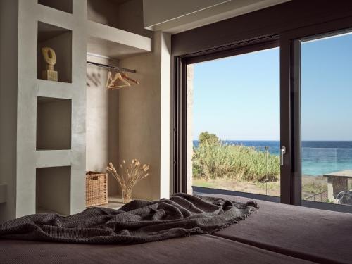 a bedroom with a bed with a view of the ocean at Seaside Luxury LaSoleil Villa, Zante Zen By ThinkVilla in Psarou