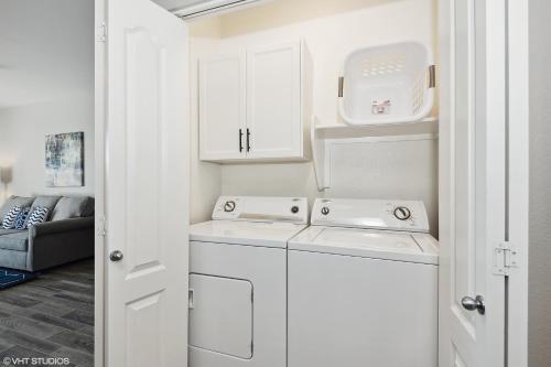 a small kitchen with white cabinets and a washer and dryer at Ascent North Scottsdale Pool Gym Apartments Near Mayo and Scottsdale Quarter in Scottsdale