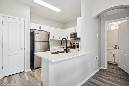 a white kitchen with a sink and a refrigerator at Ascent North Scottsdale Pool Gym Apartments Near Mayo and Scottsdale Quarter in Scottsdale