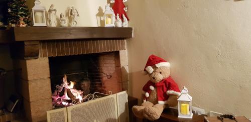 a teddy bear in a santa hat sitting next to a fireplace at Casale Cisanello in Pisa