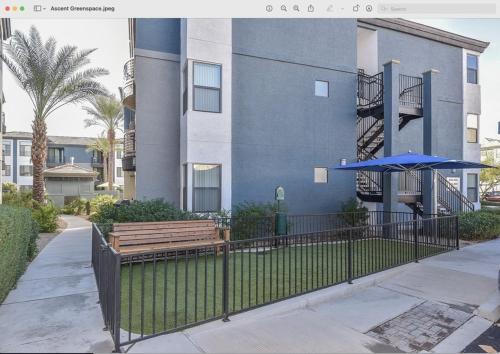 a blue building with a bench and a blue umbrella at Ascent North Scottsdale Pool Gym Apartments Near Mayo and Scottsdale Quarter in Scottsdale