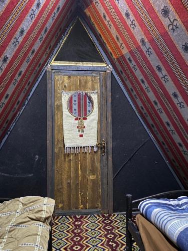 Una puerta en una tienda con una bandera. en Wadi Al-Hassa camp en Khawkhah