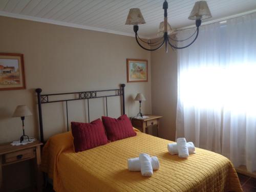 1 dormitorio con 1 cama con 2 toallas en La Casa de Marite Apart, un lugar para disfrutar en El Calafate