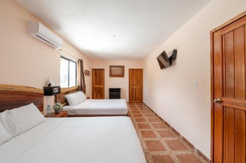 a bedroom with two beds and a window at Hotel El Perico Marinero in Río Lagartos