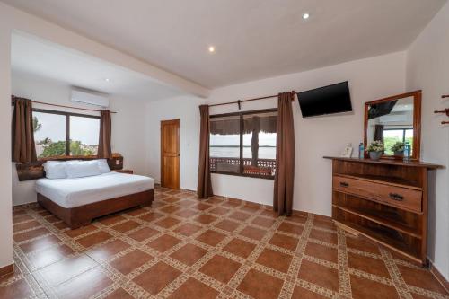 a bedroom with a bed and a television in it at Hotel El Perico Marinero in Río Lagartos