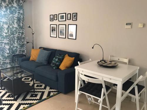 sala de estar con sofá azul y mesa en Ático 2 Dormitorios en campo de Golf Guadalmina, Marbella, en Marbella