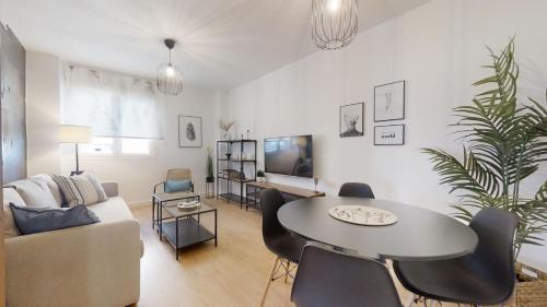 a living room with a table and a couch at Renfurbis Vista Moderno 2 Rooms in Jerez de la Frontera