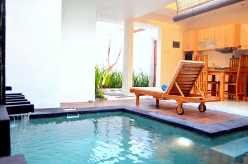 a chair sitting next to a swimming pool at The Jas Villas in Seminyak