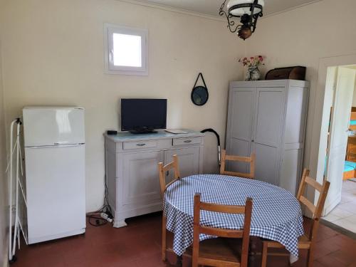 Il comprend une cuisine équipée d'une table, d'un réfrigérateur, d'une table et de chaises. dans l'établissement Charmette Petit, à Mimizan