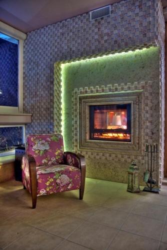 a living room with a chair and a fireplace at Dryades Hotel in Naousa Imathias