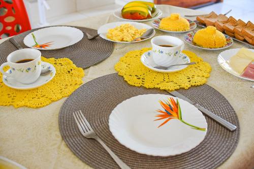 a table with two cups of coffee and plates of food at Casa DasCli in Camocim