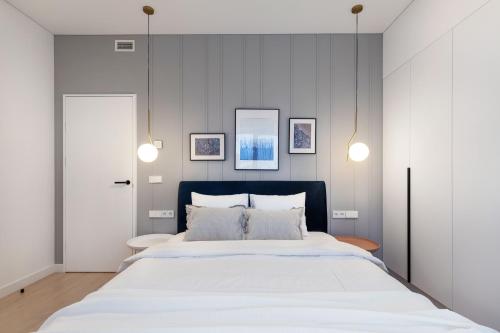 um quarto com uma grande cama branca e 2 luzes em #stayhere - Brand New & Ultra Modern 2BDR Upscale Neighbourhood Paupys em Vilnius