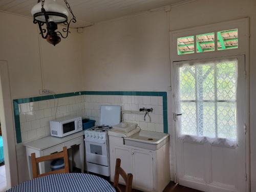 une petite cuisine avec une cuisinière et un micro-ondes dans l'établissement Charmette Petit, à Mimizan