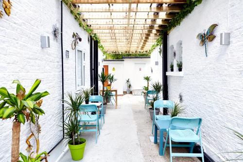 un patio vacío con sillas y plantas azules en United Lodge Hotel, en Londres