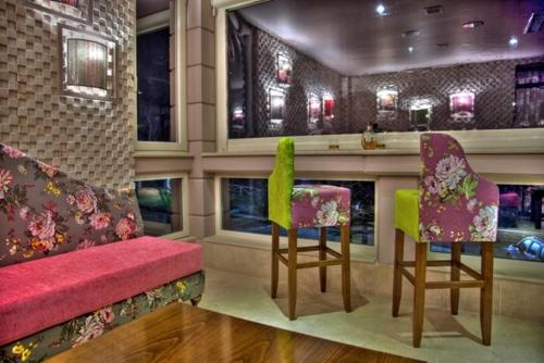 a bar with two chairs and a red bench at Dryades Hotel in Naousa Imathias