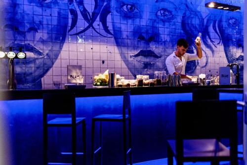 a man standing behind a bar in a restaurant at Hotel Blue Inspired by Manna in Nijmegen