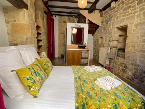 ein Schlafzimmer mit einem Bett und einer Steinmauer in der Unterkunft Maison de Charme dans la Cité in Sarlat-la-Canéda