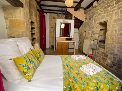una camera da letto con un letto e un muro di pietra di Maison de Charme dans la Cité a Sarlat-la-Canéda