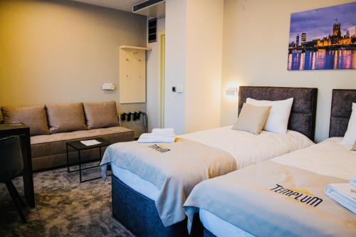 une chambre d'hôtel avec deux lits et un canapé dans l'établissement Templum apartments - Slavija square, à Belgrade