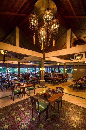 a restaurant with tables and chairs and chandeliers at Chanalai Garden Resort, Kata Beach in Kata Beach