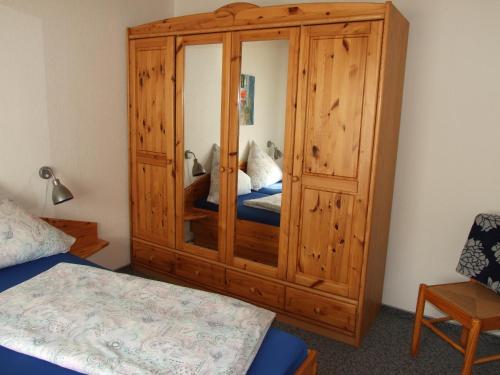 un grande armadio in legno in una camera con letto di Whg 4 - Ferien auf einem Resthof a Schönhagen