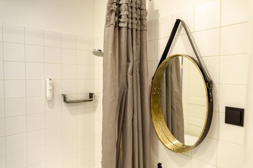 a bathroom with a mirror and a shower curtain at Central 1-bedroom Apartment with Bath & Balcony in Tallinn