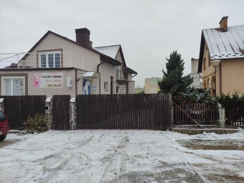 une clôture en bois devant une maison dans l'établissement Apartament Chopina, à Suwałki