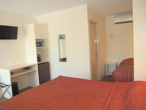 a hotel room with a bed and a desk at Murray River Motel in Swan Hill