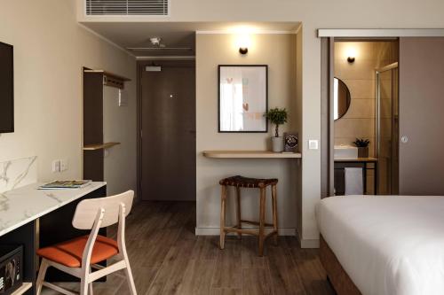 a bedroom with a bed and a desk and a chair at Strand Suites by NEU Collective in Il-Gżira