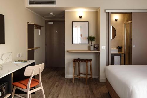 Schlafzimmer mit einem Bett, einem Schreibtisch und einem Stuhl in der Unterkunft Strand Suites by NEU Collective in Gżira