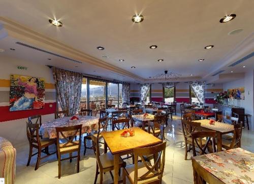 a restaurant with tables and chairs in a room at Dryades Hotel in Naousa Imathias
