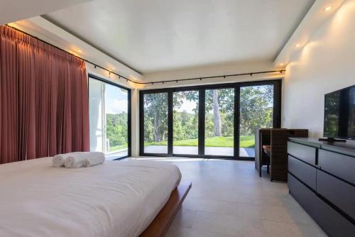 - une chambre avec un grand lit et une grande fenêtre dans l'établissement Stunning 3-Bed Villa in Chiang Mai, à Chiang Mai