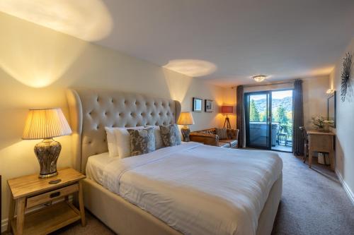 a bedroom with a large bed and a table with a lamp at Lakes Hotel & Spa in Bowness-on-Windermere