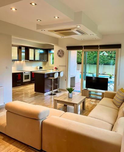 a living room with a couch and a kitchen at El Soleo Luxury Villa in Limassol