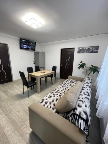 a bedroom with a bed and a table with chairs at Casa Pietrele Doamnei in Câmpulung Moldovenesc