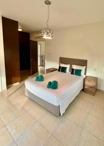 a bedroom with a large bed with two green pillows at El Soleo Luxury Villa in Limassol